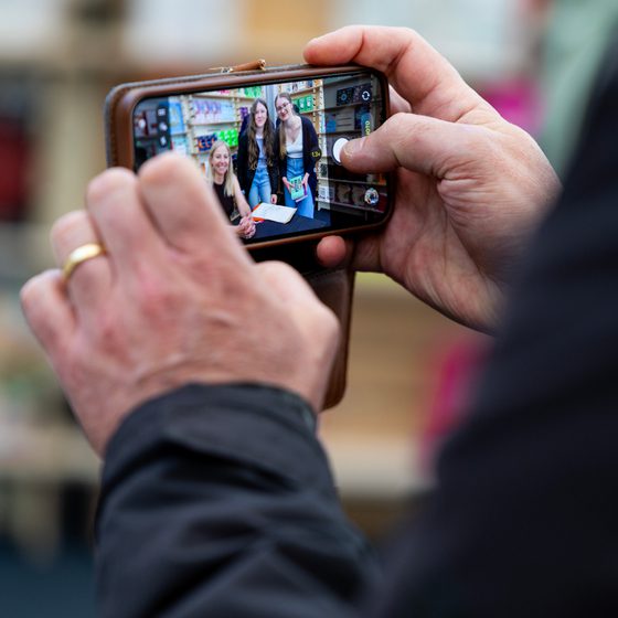 A Festival-goer taking pictures on their smartphone