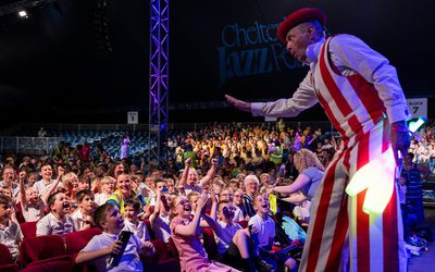 A shot from the stage of the audience at Jazz Concert for Schools 2025 with a stilt walker in shot