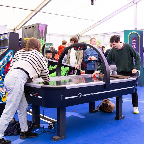 Two people playing a game of table hockey in The Arcade